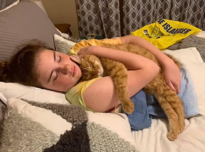 Ein Teenie kuschelt mit ihrer Katze